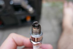 Damaged Spark Plug Close-up of a spark plug with dark deposits on the electrode.