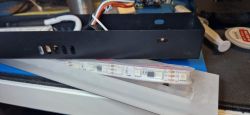Open Interior of LED Lamp with LED Strip The image shows an open black LED lamp casing with visible LED strips and wiring.