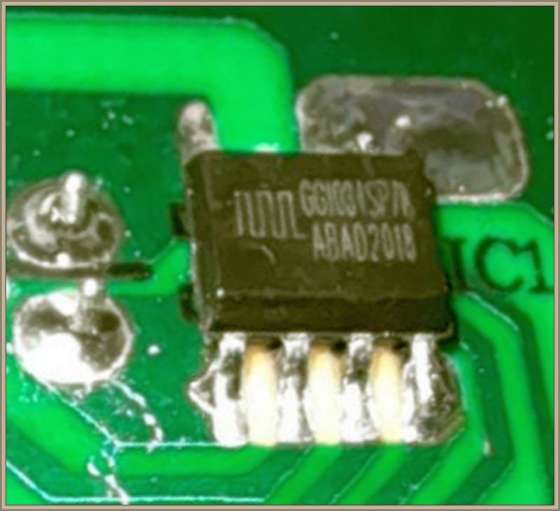 Zbliżenie na chip elektroniczny na zielonej płytce drukowanej.