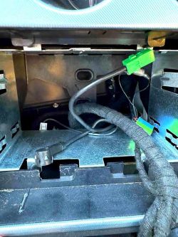 Wnętrze wnęki samochodowej z widocznymi kablami i przewodami.