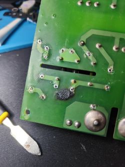 Zwęglona płytka PCB z uszkodzonym laminatem i śladami przypaleń przy punktach lutowniczych