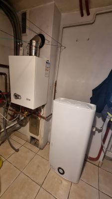Gazowy kocioł dwufunkcyjny i bojler elektryczny w pomieszczeniu gospodarczym.