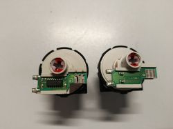 Dwa elektroniczne presostaty z widocznymi płytkami PCB i złączami.