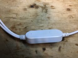 LED Strip Controller on Wooden Surface White plastic LED strip controller on a wooden surface.
