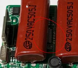 Electronic circuit board with two large capacitors labeled 250VAC505J.