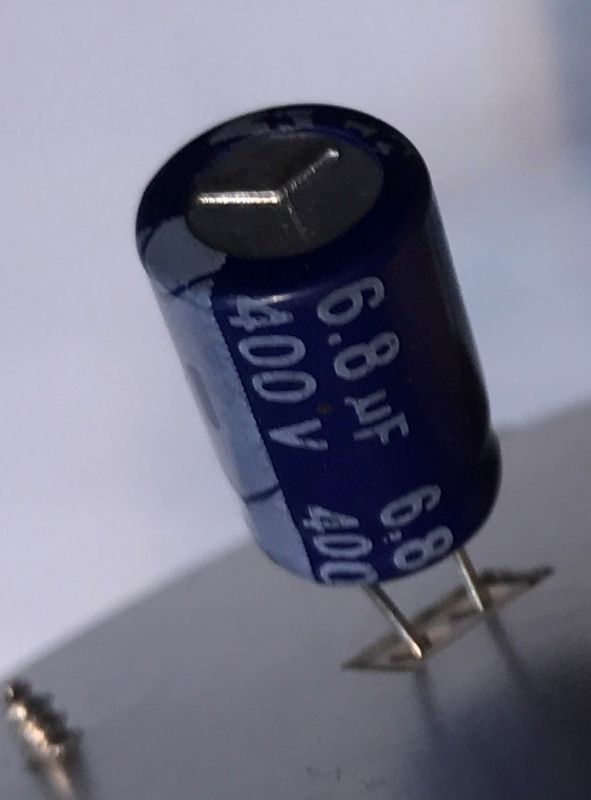 6.8 µF 400 V Capacitor on Circuit Board 6.8 µF 400 V electrolytic capacitor on a circuit board.