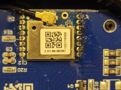 Circuit Board with Electronic Component Close-up of a blue circuit board with an electronic component and a sticker with a QR code.
