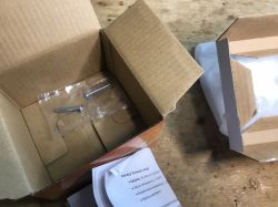 HY609-WE Thermostat Package Contents Open box of the HY609-WE thermostat with visible mounting screws and instructions.