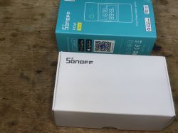 Sonoff POWR316D Elite16A boxes on a wooden surface.