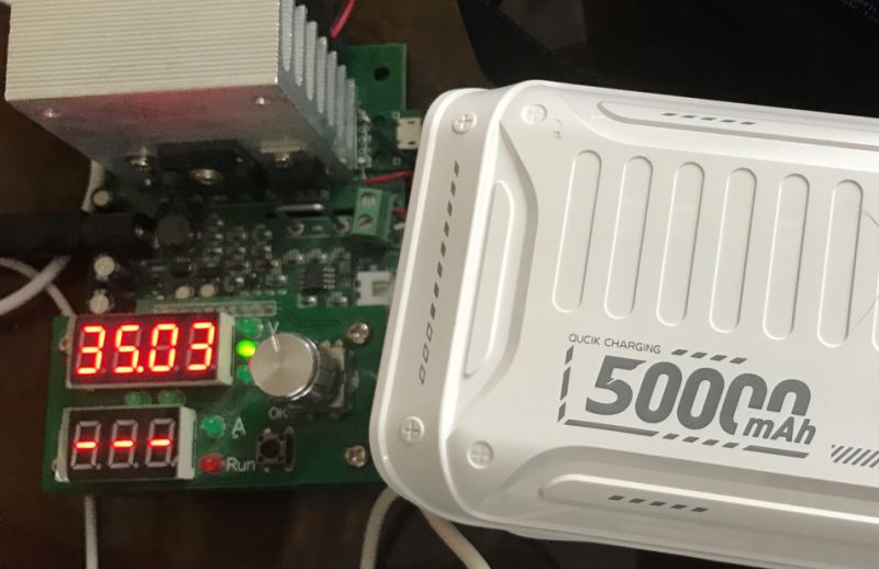 Biały powerbank 50000 mAh podłączony do testera z wyświetlaczem pokazującym 35.03 V