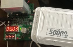 Biały powerbank 50000 mAh podłączony do testera z wyświetlaczem pokazującym 35.03 V