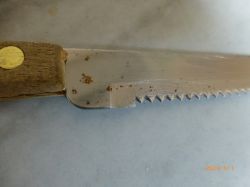 Nóż z drewnianym uchwytem z widocznymi plamami rdzy na ostrzu.