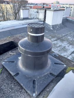 Plastikowy wywietrznik na dachu budynku z kratką u góry