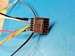 Zigbee XT‑ZB2 module with soldered wires on a blue mat