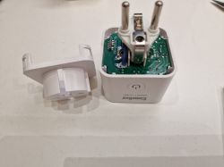 Smart plug with an open case, revealing the internal PCB.