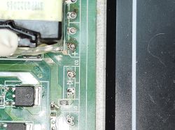 Damaged transformer on a printed circuit board Close-up of a damaged transformer on a green PCB