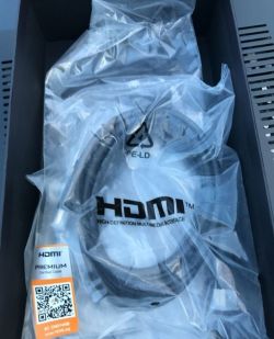HDMI cable in a clear plastic bag inside a black box.