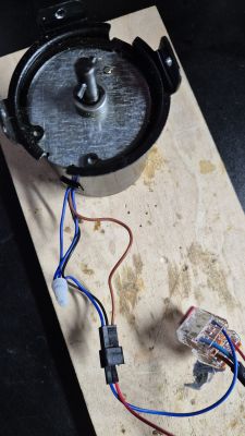 Silnik elektryczny z przewodami podłączony do deski.