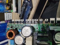 Płytka elektroniczna z rzędem tranzystorów MOSFET na górze i dużymi kondensatorami oraz dławikiem