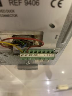 Close-up of the back of a Fermax Veo Duox 9406 intercom showing colored wires and connectors.