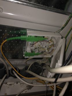 Gniazdo telekomunikacyjne z podłączonymi przewodami światłowodowymi.