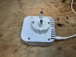 Electric Plug Adapter on Wooden Surface White electric plug adapter on a wooden surface.