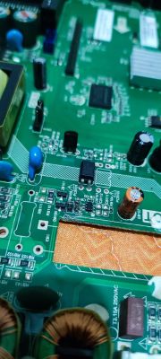 Close-up of a green circuit board with various electronic components and identification markings.