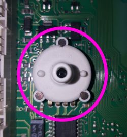 Zbliżenie na plastikowy czujnik na płytce PCB modułu elektronicznego, zaznaczony różowym okręgiem