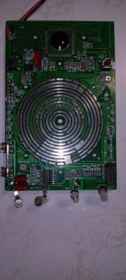 A printed circuit board with circular traces and various electronic components.