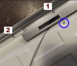 Close-up of a panel with markings for different types of screws and a location for the safety cable.