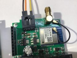 Close-up of a circuit board with a WBR1 module, antenna, and wired connector.