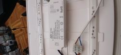 Inside a LED light fixture: LED driver, LED strips, and terminal block with wires