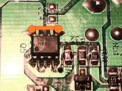 Close-up of a PCB with an SMD IC; red marker indicates a bridge between two pins