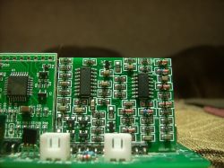 Płytka drukowana z dwoma przylutowanymi modułami i komponentami elektronicznymi.