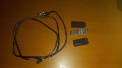 A photo of a USB-UART converter with partially removed casing on a wooden surface next to a cable.