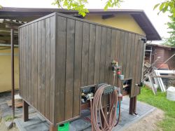 Large wooden box with an irrigation system in a garden.