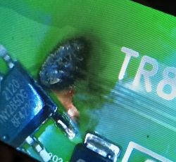 Spalony element na zielonej płytce PCB obok oznaczenia TR8
