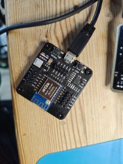 Electronic module with a USB cable connected on a wooden table.