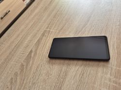 Smartfon leży ekranem do góry na drewnianym blacie