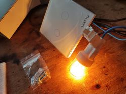 Smart Avatto Light Switch Smart Avatto light switch with backlight and accessories on a wooden surface.