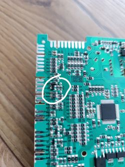 Fragment płytki PCB z elementem oznaczonym jako Q8, zaznaczonym białym kółkiem.