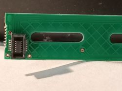 Close-up of a green touch panel with a connector and two rectangular openings