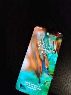 Telefon Samsung A40 z zablokowanym ekranem wzoru leżący na ciemnym tle.