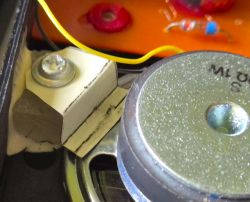 Close-up of speaker unit and plastic mounting bracket with screw inside a radio housing