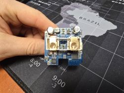 WF09 PCB board without programmer pads, held over a world map mousepad