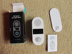 PIR Sound and Light Alarm Set PIR alarm device set with packaging and manual.
