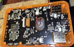 Inside of handheld console with Rockchip RK3326 and soldered speaker visible.