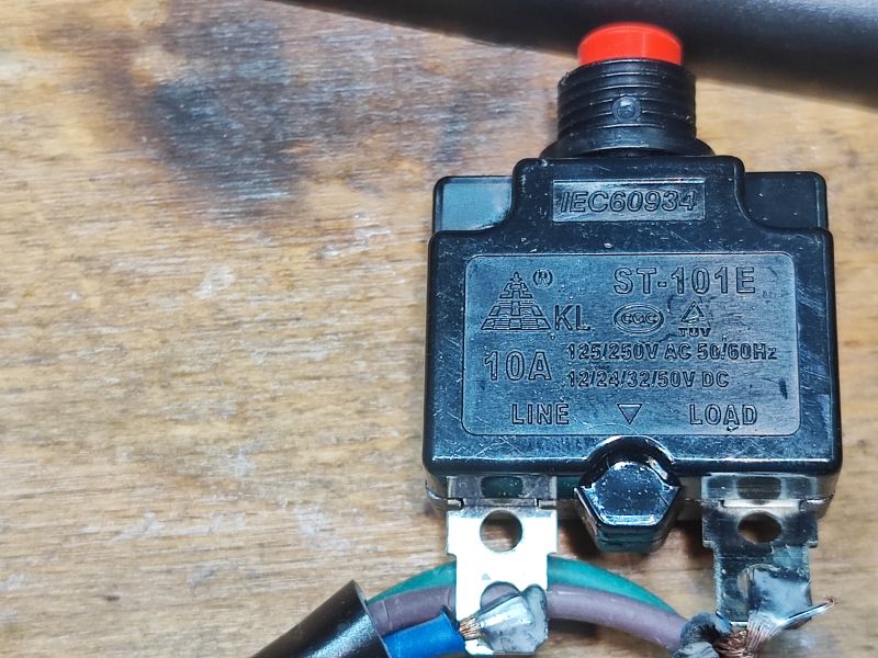 Bimetaliczny wyłącznik nadprądowy ST-101E na drewnianym tle