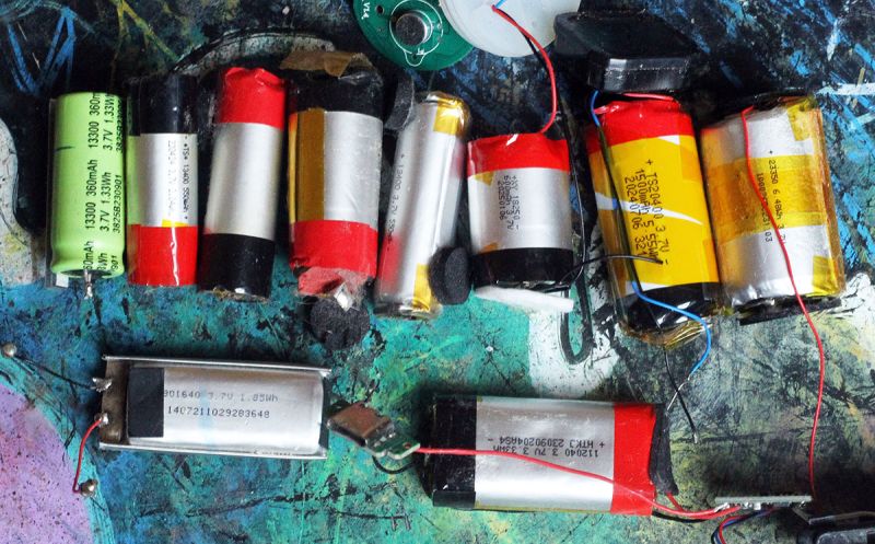 Close-up of various lithium-ion batteries on a colorful textured surface