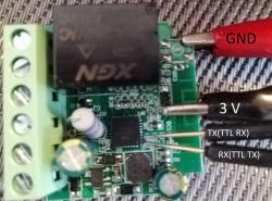Close-up view of connections on an electronic board with wires labeled GND, 3V, TX (TTL RX), and RX (TTL TX).